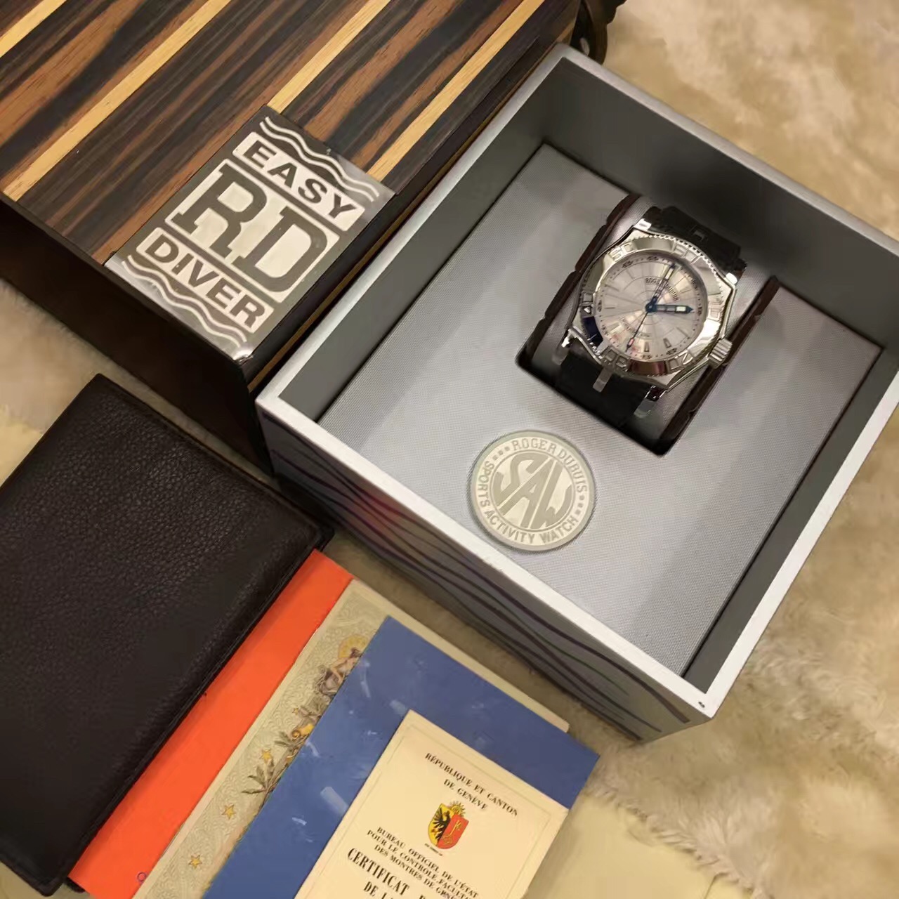 RogerDubuis 罗杰杜彼，?SE 46 57。46毫米表径，精钢表壳?18K白金圈，银色面盘，背透自动上弦机械机芯。 全套附件齐全。