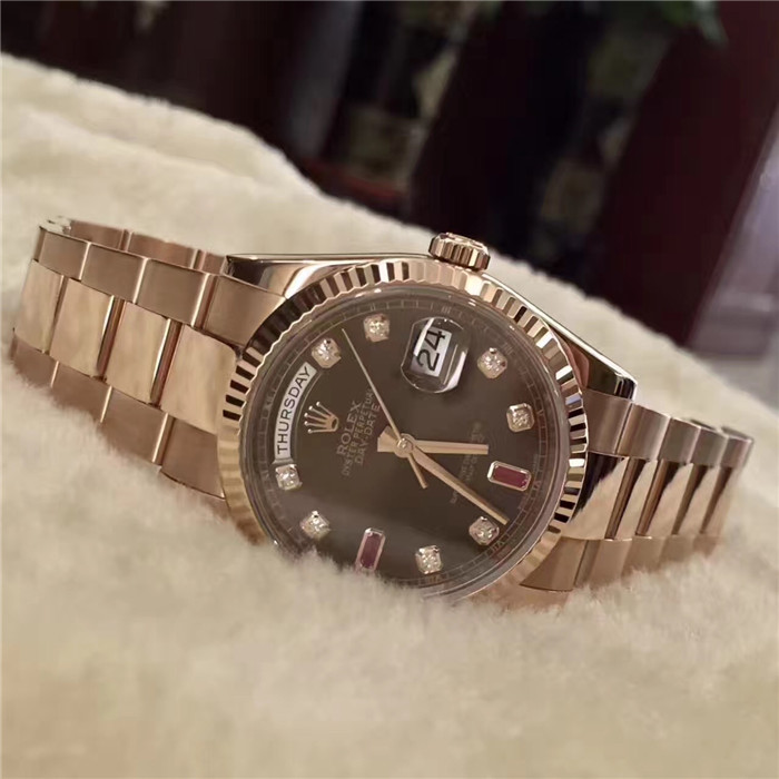 Rolex 劳力士 星期日历型系列，118235，18k玫瑰金，36mm表径，巧克力色表盘镶有钻石及红宝石，18ct金镶托镶有钻石，6及9钟点标记镶有长方形红宝石。中央时、分及秒针，表面设瞬跳日历及星期易调设定；秒针暂停功能以准确调校时间蚝式三排链节表带，隐蔽式摺叠皇冠带扣。旋入式18K玫瑰金底盖，自产 3155型自动上链机械机芯，动力储备48小时。